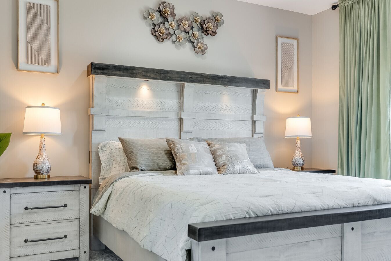 Une chambre à coucher comprenant un lit, des tables de chevet, des lampes et des éléments décoratifs muraux.