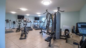 A gym with treadmills, elliptical machines, and weight equipment.