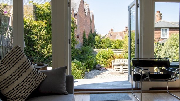 Un salon moderne avec un canapé, un banc et un piano.
