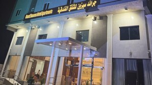 A hotel with multiple floors, a well-lit entrance, and a sign indicating it is a hotel.