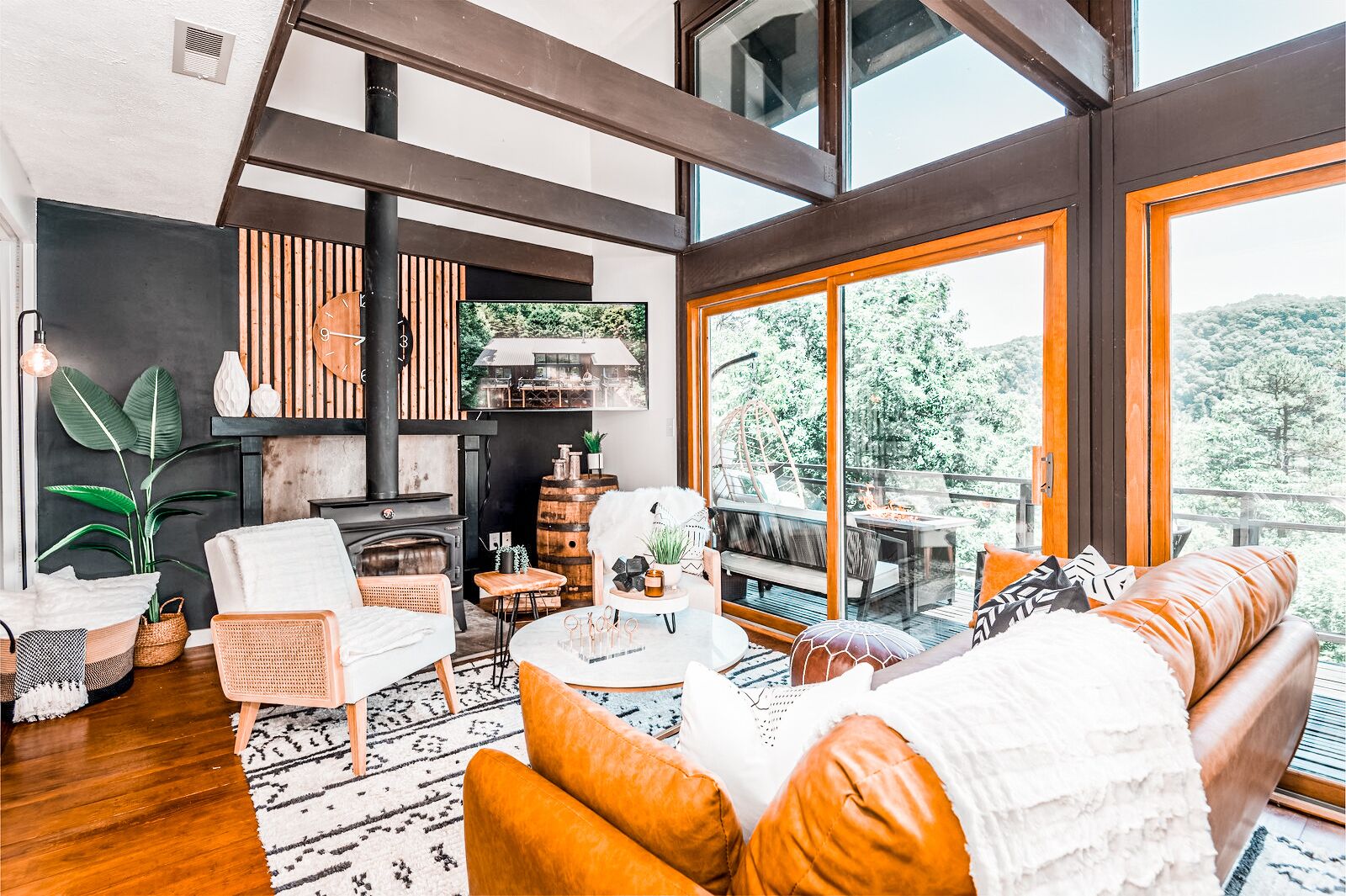 A modern living room with a fireplace, large windows, and a cozy seating area.