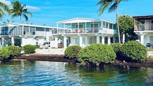 Une propriété située au bord de l’eau, comprenant plusieurs niveaux, dont un balcon offrant une vue sur l’eau.