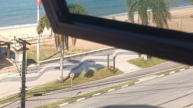 A view of a beach with palm trees and a clear sky. - Seafront Apartment with Pool in Martim de Sá (Caraguatatuba)