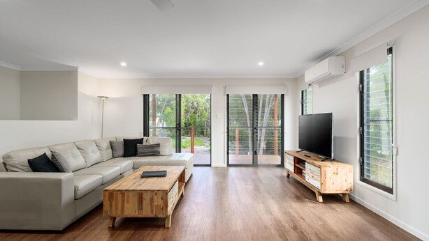 Una sala moderna con sofá, mesa de centro y mueble para televisión.