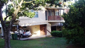 Une maison à deux étages avec un garage et une voiture garée à l’intérieur.