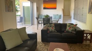 Un salon comprenant un canapé, une table basse et un coin repas avec des chaises et une table.