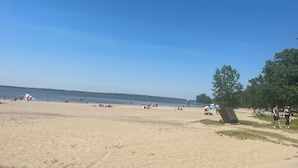 A beach with people relaxing and sunbathing.