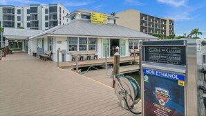 A marina with a gas station, a boat house, and a building with multiple windows. - Bayfront Condo w/ Sunrise Views & Resort Amenities (Marco Island)