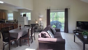 A spacious living area with a dining table, sofa, and a TV. - Family and Workation Retreat (Tobyhanna)