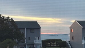 Un quartiere residenziale con case, un parcheggio e un tramonto sullo sfondo.