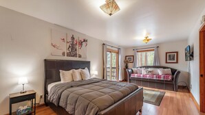 Un dormitorio con una cama grande, una mesita de noche y un sofá.