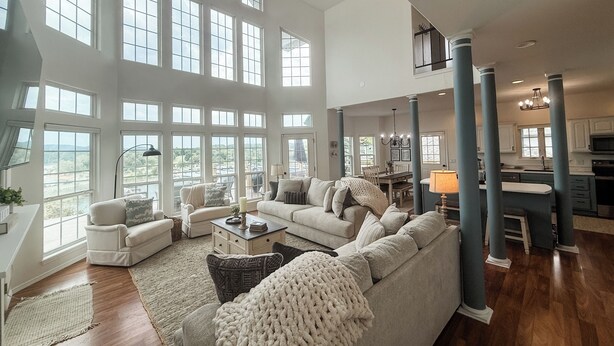 A spacious living room with a large sectional sofa, a dining area, and a kitchen visible through an open layout.