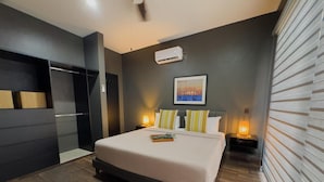 A modern bedroom with a large bed, bedside lamps, a cityscape painting, and a built-in wardrobe. - Modern 2‑Bed Condo in Golden Zone: Walk Everywhere! (Mazatlan)