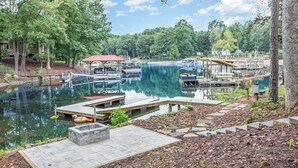 A marina with docks, boats, and a wooden pier. - Ultimate Lake Norman Getaway - 6BR, Pool, hot tub, Fire Pit, Kayaks, & Boat Dock (Mooresville)