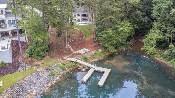 A riverside property with a dock, a swimming pool, and a well-maintained garden. - Ultimate Lake Norman Getaway - 6BR, Pool, hot tub, Fire Pit, Kayaks, & Boat Dock (Mooresville)