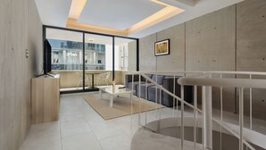 Un salon moderne avec un canapé, une table basse et un escalier.