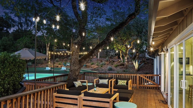 A wooden deck with outdoor furniture, string lights, and a pool. - Luxury 6-Sleeper: Pool, HotTub, 8 mins to Sonoma Square, and Deluxe Coffee Bar! (Sonoma)