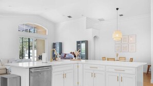 A modern kitchen with white cabinetry, a central island, and a dishwasher.