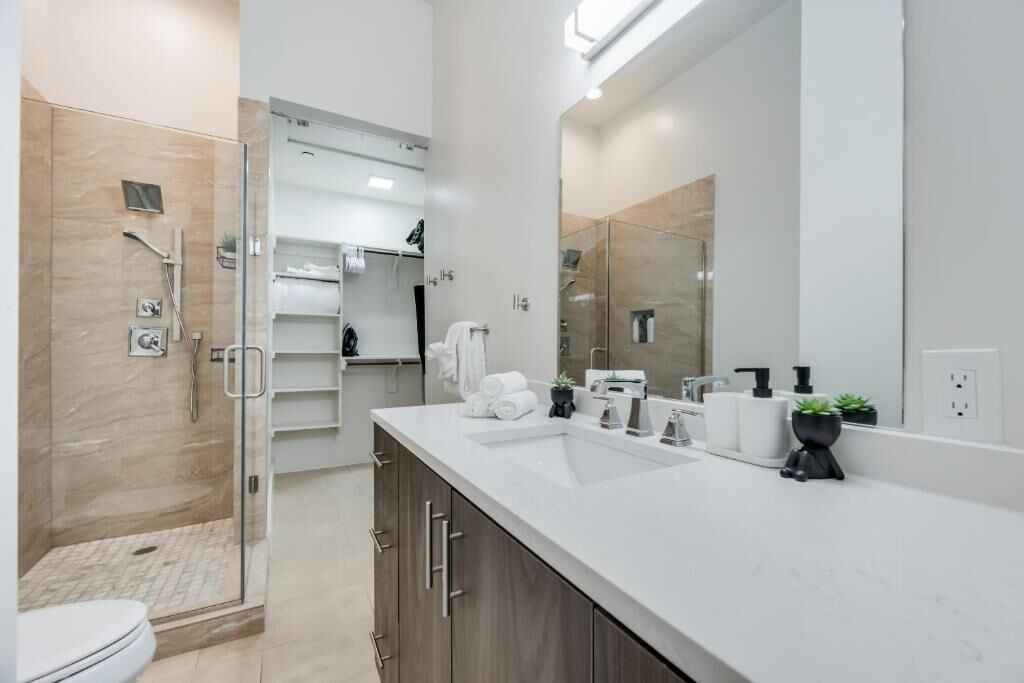 Ein modernes Badezimmer mit Dusche, Toilette und Waschtisch mit großem Spiegel.