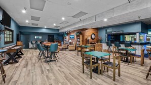 Un restaurante con piso de madera, paredes azules y una zona de bar.