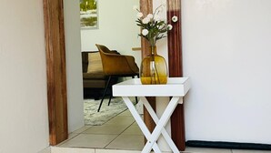 Ein weißer Tisch mit Blumen in einem Raum mit Fliesenboden und Holzelementen.