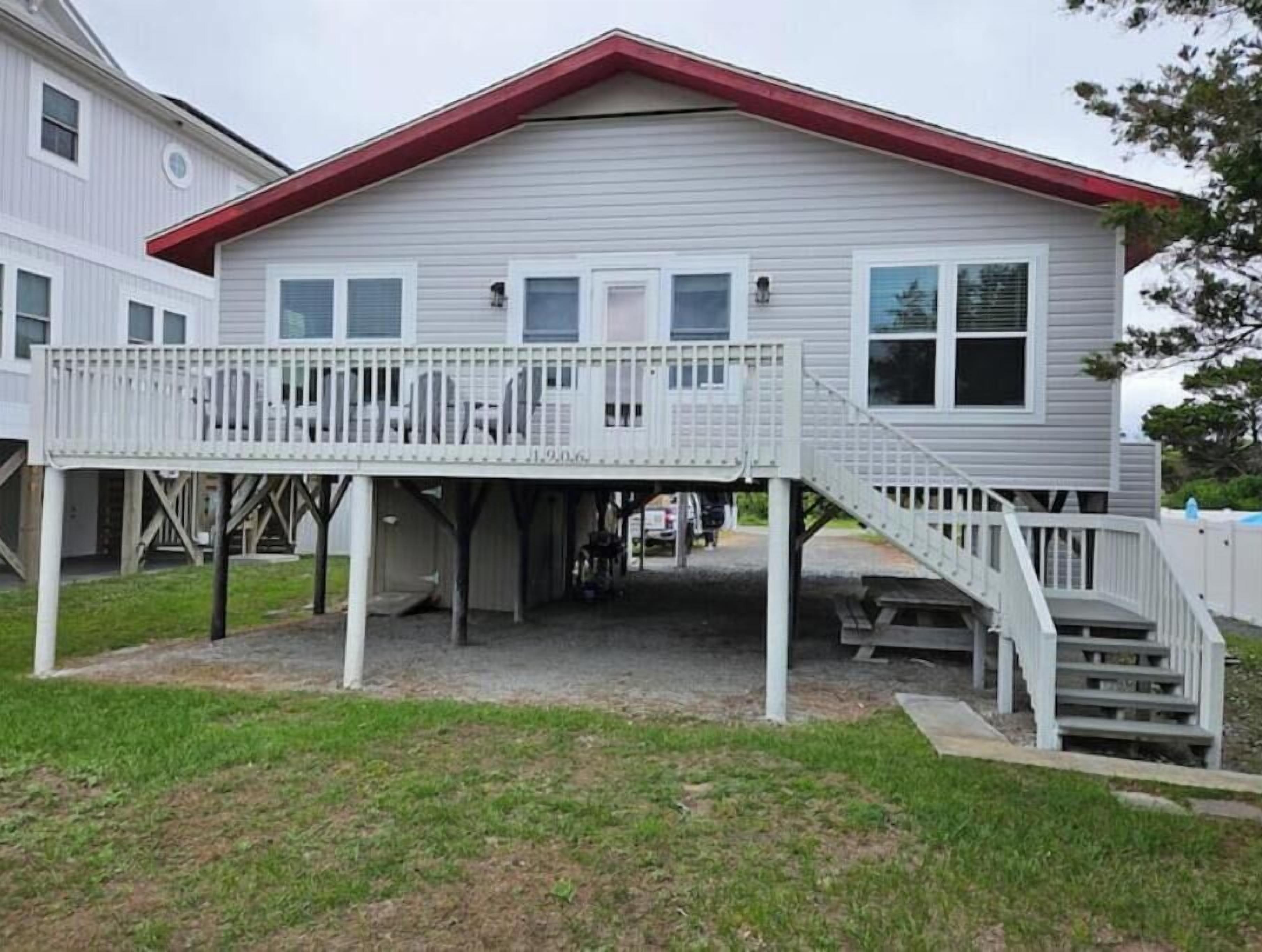 A two-story house with a covered porch and a small staircase leading to the upper level.