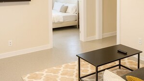 A modern living room with a flat-screen TV, a sofa, a coffee table, and a patterned rug. - Stay in a centrally located home, 1.5 miles from downtown Ann Arbor. (Ann Arbor)
