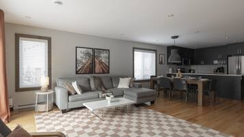 Un salon moderne avec un canapé, une table basse et un coin repas.