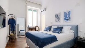 Un dormitorio con cama, escritorio y silla.