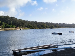 A calm lake with boats, a dock, and a forested shoreline.