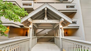 A building entrance with a sign reading "White Pine" and a covered walkway leading to the entrance.
