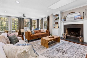 A spacious living room with a large window, a fireplace, and a sofa set. - 4/3 with pool NW Gainesville (Gainesville)