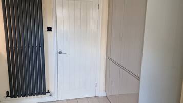 A room with a white door, a radiator, and a wardrobe.
