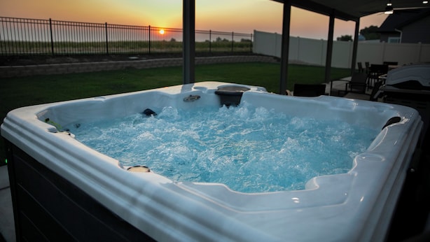A hot tub with a sunset view, a covered patio area, and a pool table. - Meridian Sunset views w/playroom and private HOT TUB (Meridian)