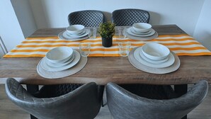A dining table set with plates, glasses, and a small potted plant. - Home In Northampton | Contractors Welcome (Northampton)