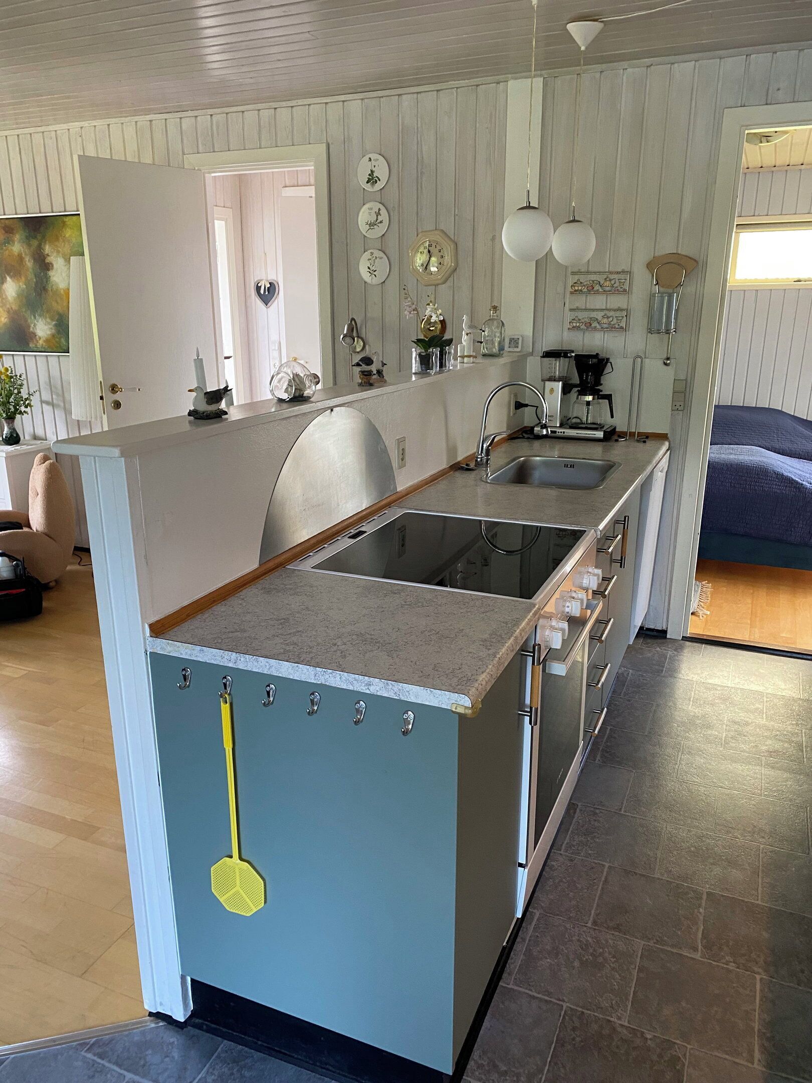 Een kleine keuken met een inbouwfornuis, een spoelbak en een koffiezetapparaat.
