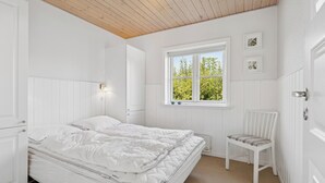 A bedroom with a bed, a window, a chair, and a wall-mounted shelf. - Peaceful cottage in scenic surroundings (Tarm)