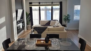 A modern living room with a sofa, dining table, and chairs.