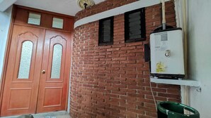 A brick wall with a white electrical box and a green bucket. - Comfortable and cozy apartment (Oaxaca de Juárez)