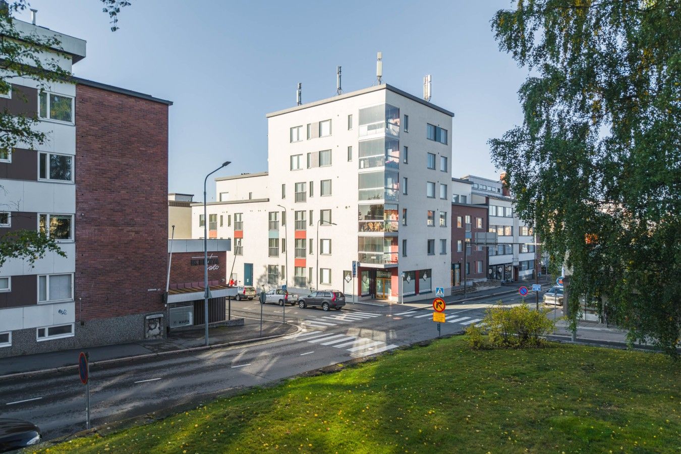 Monikerroksinen rakennus, jossa on moderni arkkitehtoninen tyyli. Siinä on yhdistelty tiili- ja valkoisia julkisivuja, ja sen edessä on jalankulkijoiden ylityspaikka.