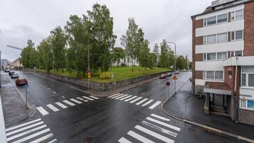 Useita ajokaistoja sisältävä tie, jossa on jalankulkijoiden suojatiet, liikenneympyrä ja rakennus, jossa on kyltti, jossa lukee ”VVRIKATU”.