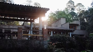 Un bâtiment traditionnel avec un toit en tuiles, des murs en briques et une structure en bois au premier plan.