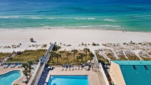Un resort sulla spiaggia con piscina, lettini e accesso diretto alla spiaggia tramite rampa.