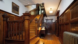 Un escalier en bois, doté d’une rampe et d’un banc à sa base.