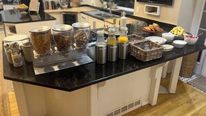 Un buffet de petit-déjeuner proposant une variété d’aliments et de boissons, le tout disposé sur un comptoir noir.