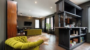 Un salon moderne avec un fauteuil vert, un meuble en bois et un tapis en cuir.