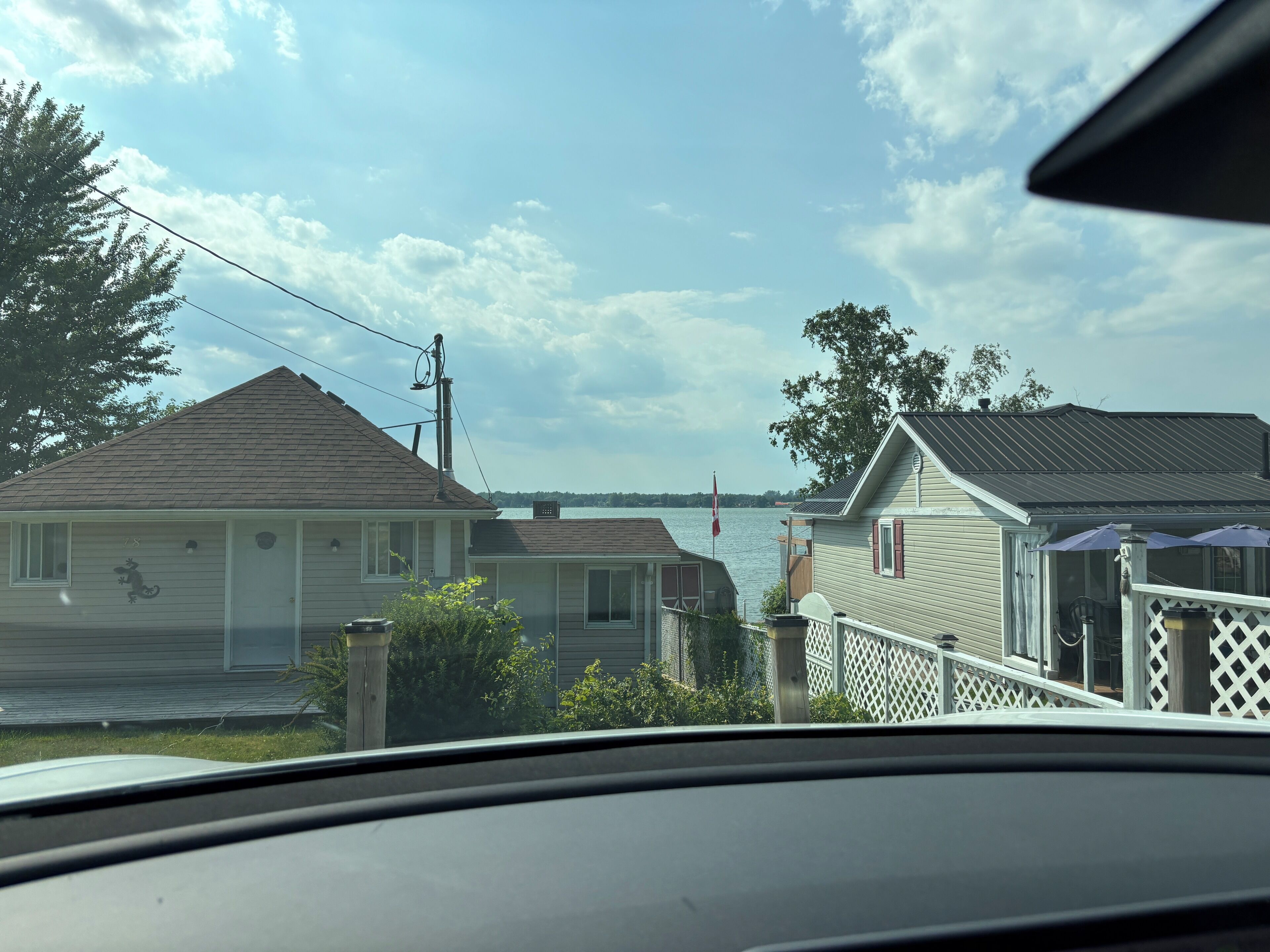 Een woonwijk met huizen aan het water, inclusief een steiger en een witte picket fence.