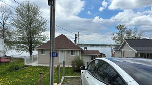 A residential area with a house marked '78', a parked car, and a dock extending into a lake.