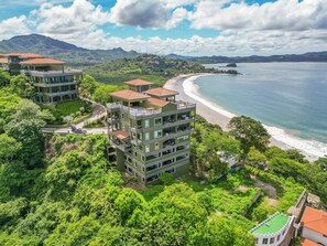 Hotel com vários andares e varandas com vista para a praia e o oceano.