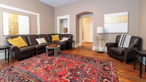 A living room with a sectional sofa, a patterned rug, and a lamp. - Salem Boutique Downtown 3BDRM Suite (Salem)